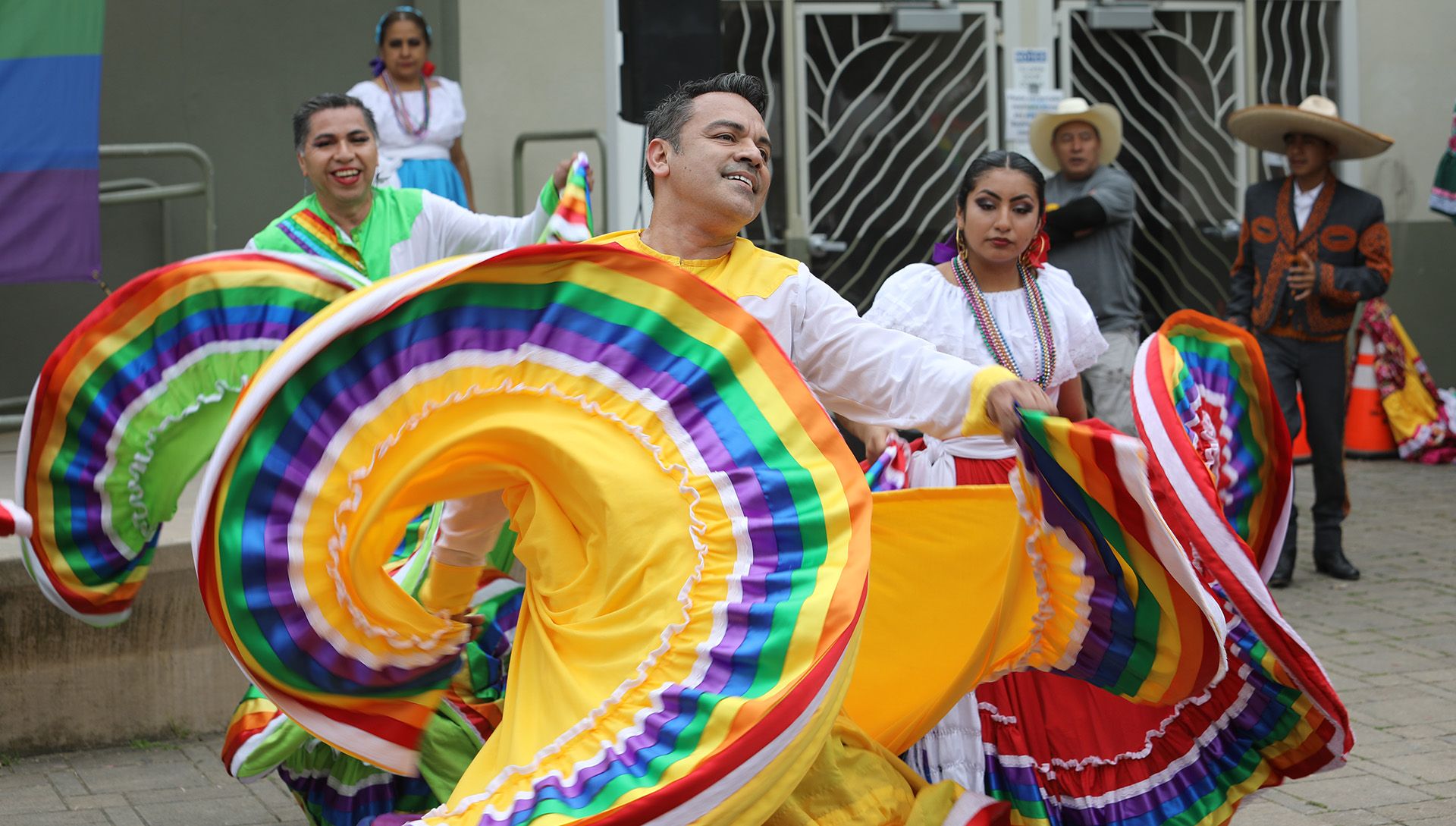 dancers from ensemble folclórico colibri flouncing their multi-colored circle skirts