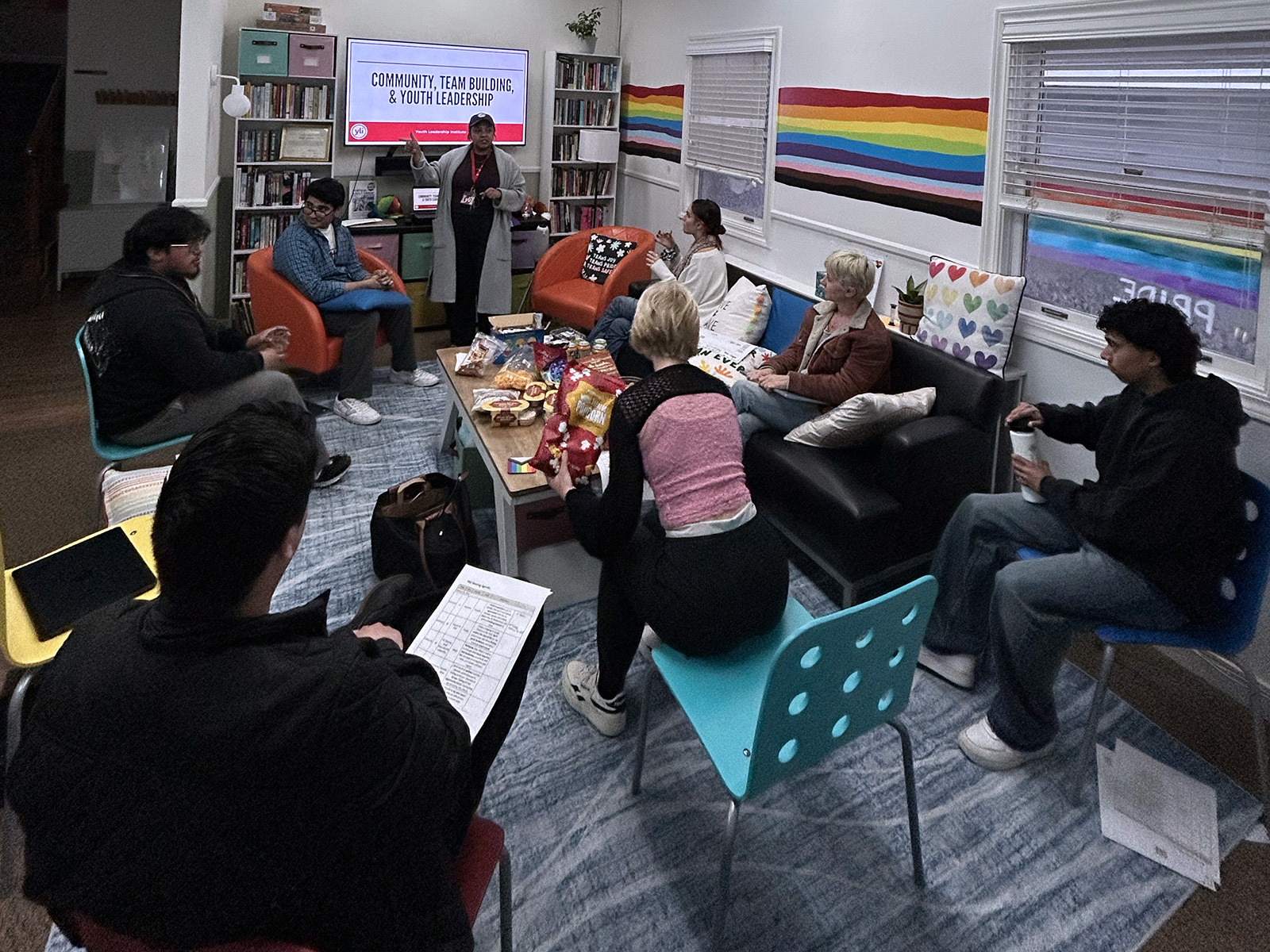 group event at CP center. 7 people are listening to a presenter in front of a screen that reads “community, team building, & youth leadership