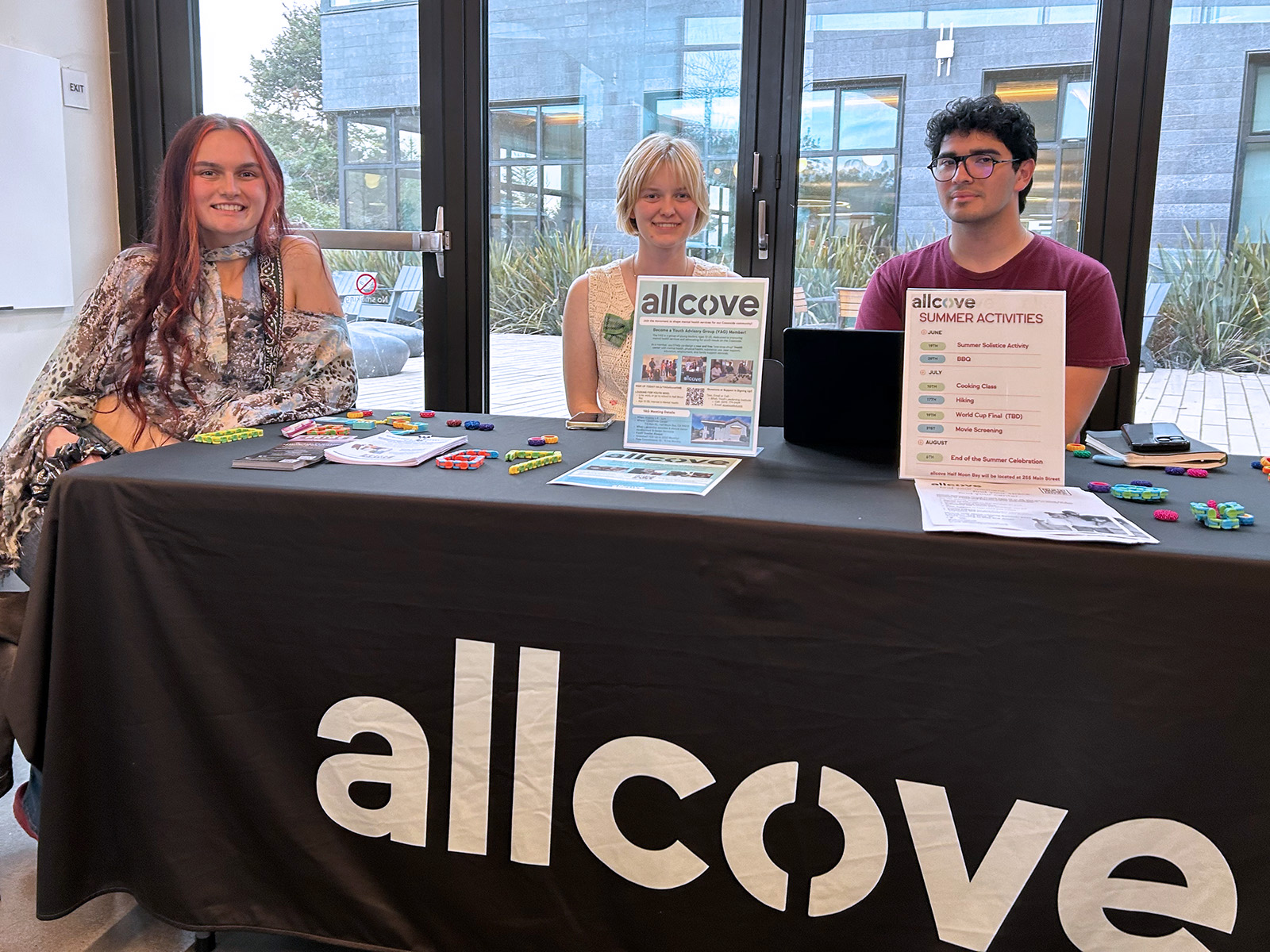 allcove table with three people and literature at the hmb library