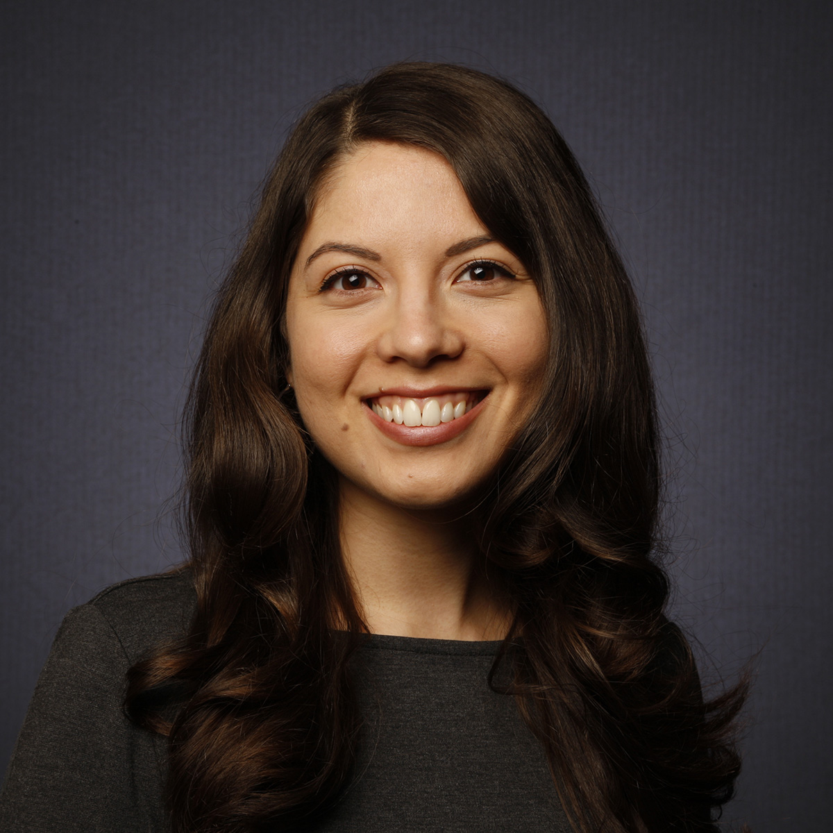 Margarita Saucedo professional studio portrait of young woman with long wavy brown hair, brown eyes, wide smile