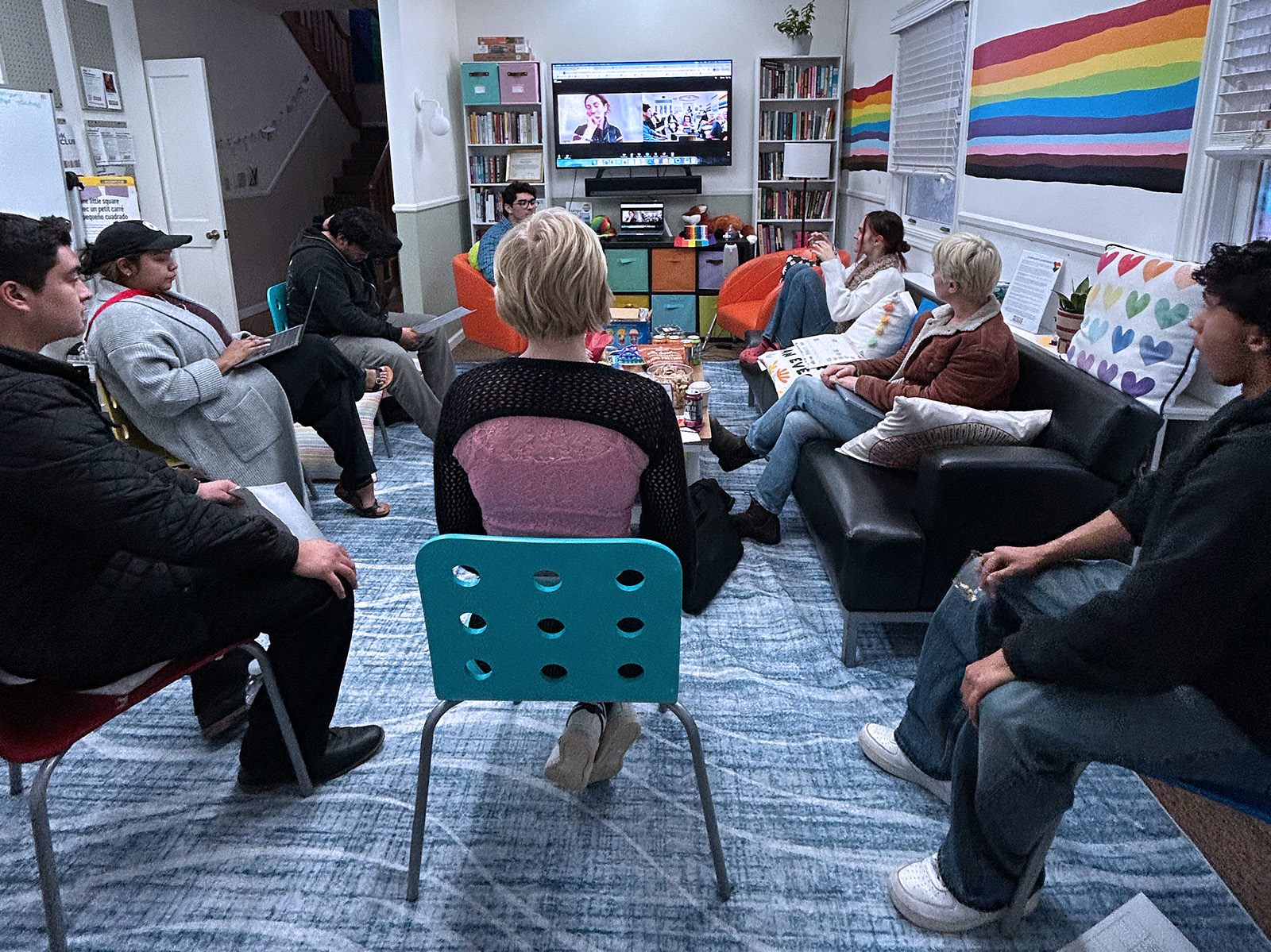 group of young people sitting in a circle around a presenter