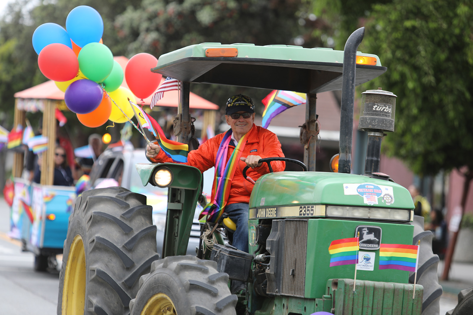 farmer john in tractor with pride decorations